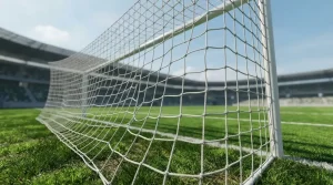 Nahaufnahme eines Fußballtornetzes vor einem grünen Spielfeld